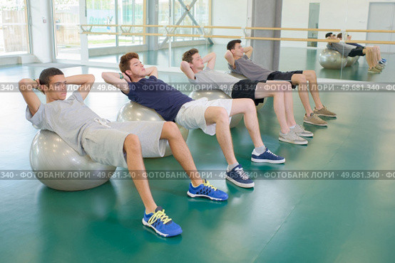 Four men exercising on aerobic balls. Стоковое фото, агентство Ingram Publishing / Фотобанк Лори