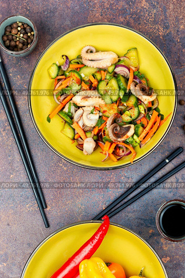 Fresh and healthy salad Asian seafood squid with vegetables and chopstick. Top view.. Spicy squid vegetables with in plate on table. Стоковое фото, агентство Ingram Publishing / Фотобанк Лори