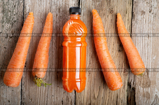 fresh carrot juice with carrots around old style wooden background . Стоковое фото, агентство Ingram Publishing / Фотобанк Лори