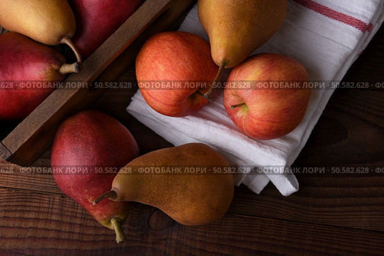 Fresh picked pears and apples in a wood crate and towel on a rustic wood table. Top view in horizontal format. . Стоковое фото, агентство Ingram Publishing / Фотобанк Лори