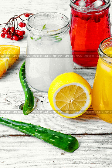 Freshly squeezed orange juice and citrus fruit in stylish glass jars. refreshing juice from fruits and aloe. Стоковое фото, агентство Ingram Publishing / Фотобанк Лори