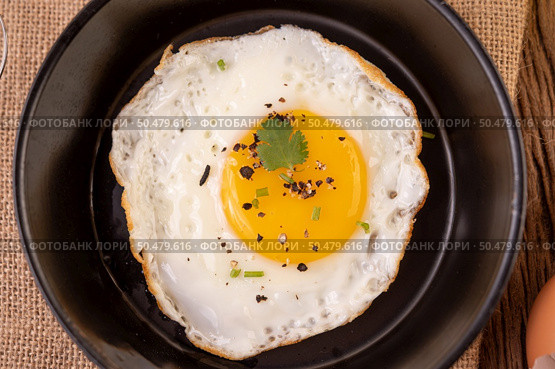 Fried eggs in a frying pan and raw eggs, organic food for good health, high in protein. Стоковое фото, агентство Ingram Publishing / Фотобанк Лори