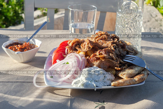 Fried pork pieces (gyros) with sauce, vegetables and French fries on the table close-up. Стоковое фото, фотограф Татьяна Ляпи / Фотобанк Лори