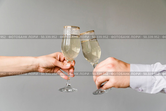 friends hands clinking glasses champagne grey background. Стоковое фото, агентство Ingram Publishing / Фотобанк Лори