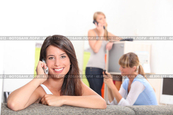 Friends using phones at home. Стоковое фото, агентство Ingram Publishing / Фотобанк Лори