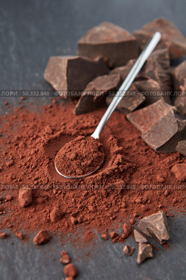 From above of organic dark bitter cocoa powder with teaspoon and heap of chocolate chunks on gray background. Delicious chocolate and cocoa powder. Стоковое фото, агентство Ingram Publishing / Фотобанк Лори