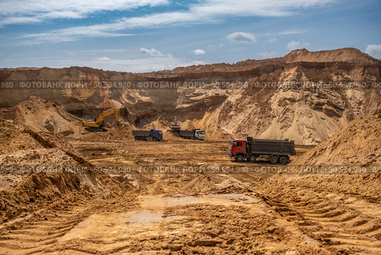 From afar - the work of a sand quarry. There is a lot of equipment, the development of minerals is underway. Стоковое фото, фотограф Дина Дамоцева / Фотобанк Лори