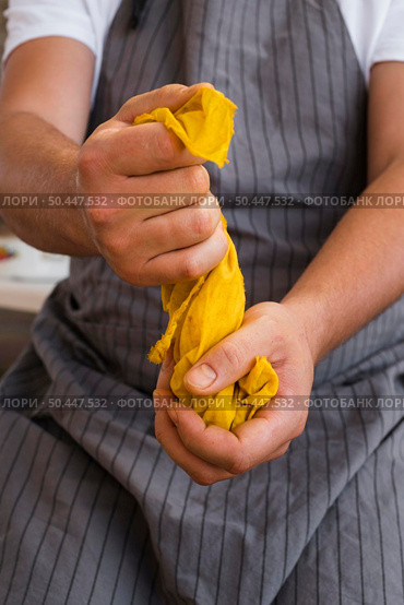 front view man squeezing cloth from natural pigment. Стоковое фото, агентство Ingram Publishing / Фотобанк Лори