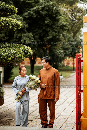 front view man woman temple with incense bouquet flowers. Стоковое фото, агентство Ingram Publishing / Фотобанк Лори