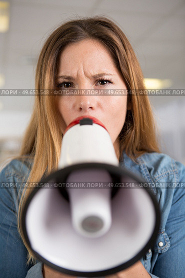 frowning woman speaking through a loud speaker. Стоковое фото, агентство Ingram Publishing / Фотобанк Лори