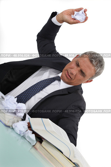 Frustrated businessman throwing scrunched-up paper. Стоковое фото, агентство Ingram Publishing / Фотобанк Лори