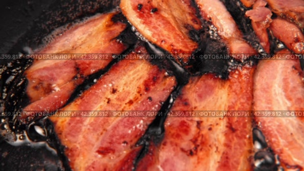 Frying Bacon Slices in a Pan. Crispy Pieces of Delicious Red Thin Smokey Bacon Fried in a Hot Skillet. Traditional Breakfast. Smoked Bacon Rasher or Strip Being Cooked. Grill. Fat High Calorie Food. Стоковое видео, видеограф Марина Демидюк / Фотобанк Лори