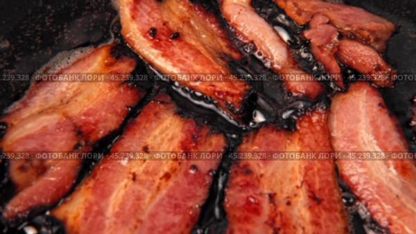 Frying Bacon Slices in a Pan. Crispy Pieces of Delicious Red Thin Smokey Bacon Fried in a Hot Skillet. Traditional Breakfast. Smoked Bacon Rasher or Strip Being Cooked. Grill. Fat High Calorie Food. Стоковое видео, видеограф Марина Демидюк / Фотобанк Лори
