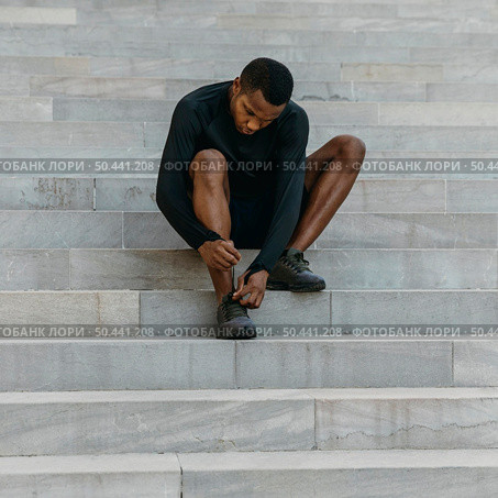 full shot man tying his shoelace. Стоковое фото, агентство Ingram Publishing / Фотобанк Лори