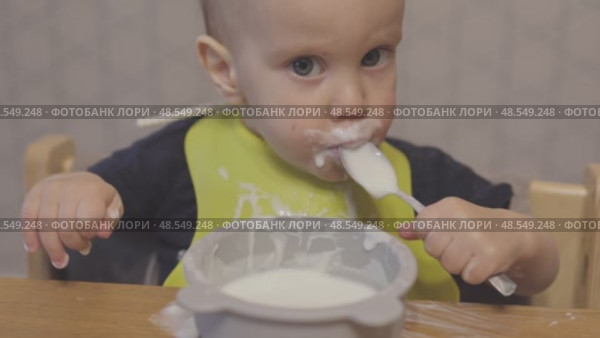 funny baby toddler learning to eat with spoon, child learn eating use teaspoon. Стоковое видео, видеограф Olesia Kondrateva / Фотобанк Лори
