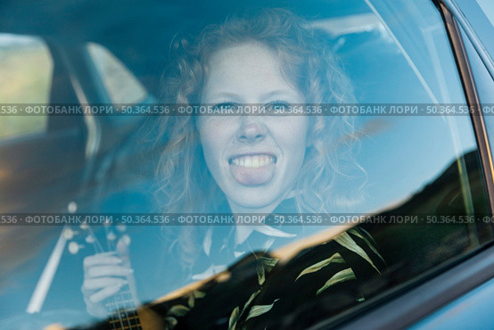 funny young woman fooling around car. Стоковое фото, агентство Ingram Publishing / Фотобанк Лори