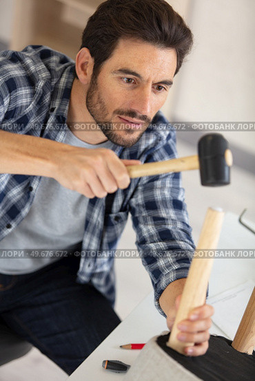 furniture assembler master with hammer. Стоковое фото, агентство Ingram Publishing / Фотобанк Лори