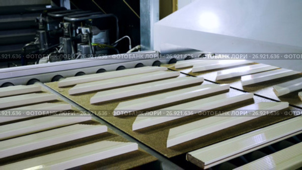 Furniture plant. Lacquered wooden parts moving on a specially equipped conveyor belt. 4K. Стоковое видео, видеограф ActionStore / Фотобанк Лори