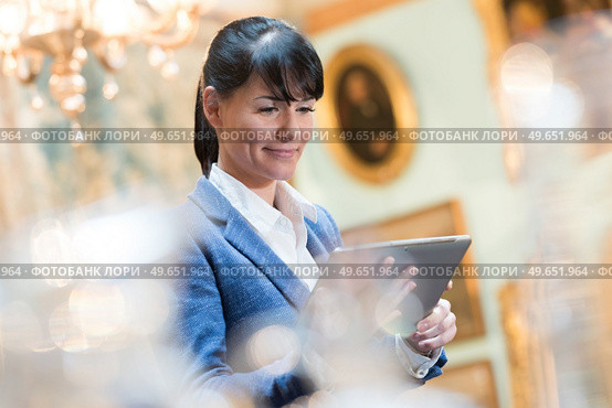 gallery curator looking at tablet. Стоковое фото, агентство Ingram Publishing / Фотобанк Лори
