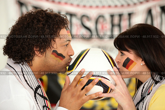 German soccer fans kissing ball. Стоковое фото, агентство Ingram Publishing / Фотобанк Лори