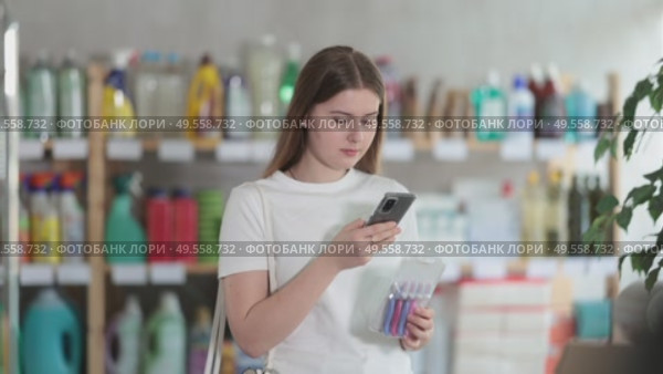 Girl buyer scans qr code on razor kit label. Стоковое видео, видеограф Яков Филимонов / Фотобанк Лори