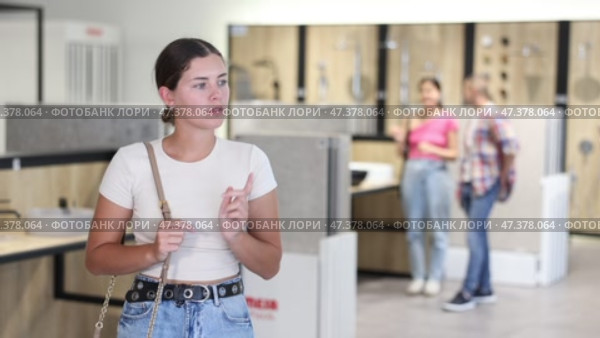 Girl chooses bathroom accessories with interest in a hardware store. Стоковое видео, видеограф Яков Филимонов / Фотобанк Лори