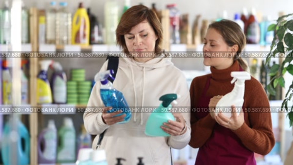 Girl consultant helps woman buyer choose household chemical spray. Стоковое видео, видеограф Яков Филимонов / Фотобанк Лори