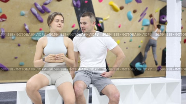 Girl gym coach and teen client standing in fitness room discussing possible options climbing. Стоковое видео, видеограф Яков Филимонов / Фотобанк Лори