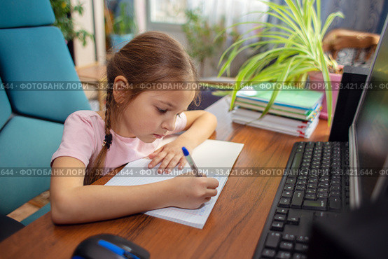 Girl schoolgirl does school homework at home in front of a computer. Стоковое фото, фотограф Екатерина Кузнецова / Фотобанк Лори