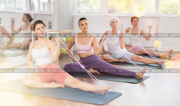 Girl using figure eight resistance band for exercise in pilates class. Стоковое фото, фотограф Яков Филимонов / Фотобанк Лори