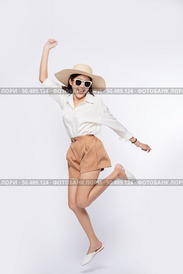 Girl wearing a white shirt and shorts wearing a hat Wear glasses and handle on the hat. Стоковое фото, агентство Ingram Publishing / Фотобанк Лори