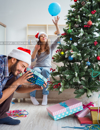 Girlfriend and boyfriend opening christmas gifts. Стоковое фото, фотограф Elnur / Фотобанк Лори