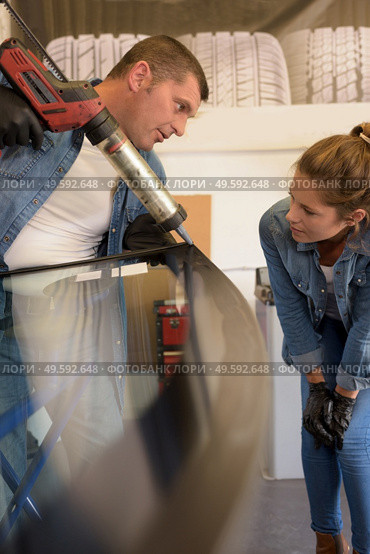 glalzier using tool to replace broken windshield. Стоковое фото, агентство Ingram Publishing / Фотобанк Лори