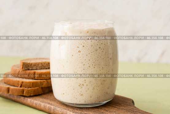 Glass jar with fresh sourdough and bread slices on table. Стоковое фото, фотограф Pixel_shot / Фотобанк Лори