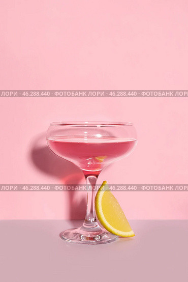 Glass of Cosmopolitan cocktail with lemon on color background. Стоковое фото, фотограф Pixel_shot / Фотобанк Лори