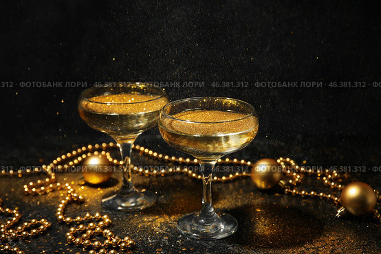 Glasses of champagne with glitters and Christmas decorations on dark background. Стоковое фото, фотограф Pixel_shot / Фотобанк Лори
