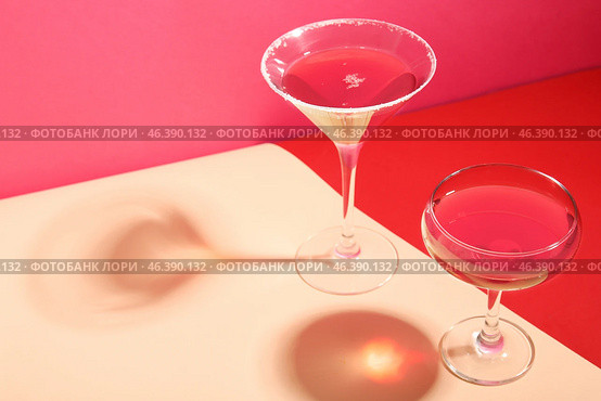 Glasses of Cosmopolitan cocktail on colorful background. Стоковое фото, фотограф Pixel_shot / Фотобанк Лори