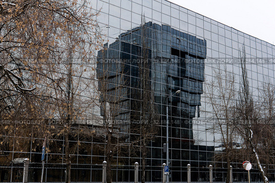 Gloomy winter cityscape - buildings with glass facades are reflected in each other. Стоковое фото, фотограф Евгений Харитонов / Фотобанк Лори