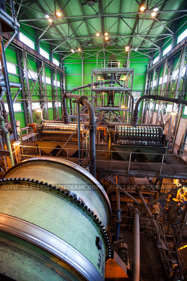 Gold ore Concentrating plant. Ball mill on front. Gold gravity spiral chute concentrator (ore spiral) and wet magnetic drum separators on background (2012 год). Редакционное фото, фотограф Alexey Rezvykh / Фотобанк Лори