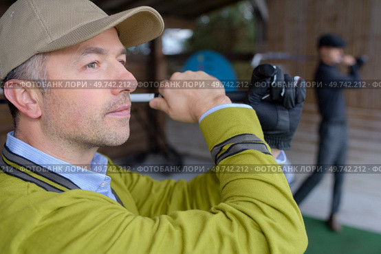 golfer choosing golf club on retail shop. Стоковое фото, агентство Ingram Publishing / Фотобанк Лори