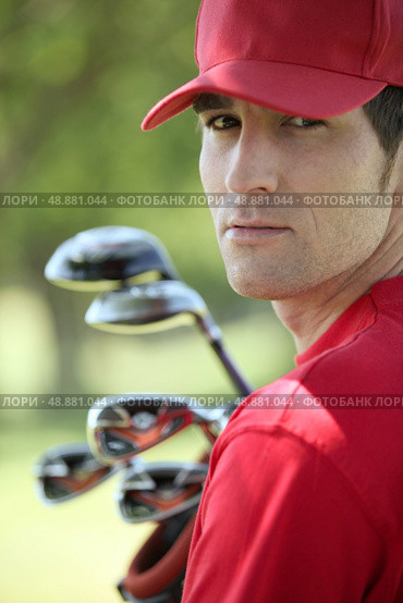 Golfer holding golf clubs. Стоковое фото, агентство Ingram Publishing / Фотобанк Лори