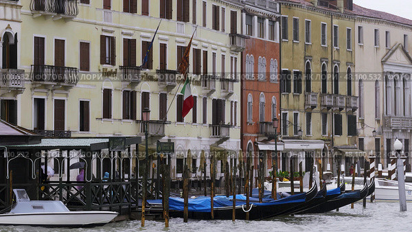 Gondolas docked on grand canal with italian flag waving. Стоковое фото, фотограф David Kashakhi / Фотобанк Лори