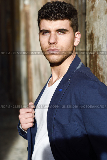 Good looking young man with blue eyes in the street. Model of fashion in urban background wearing white t-shir and blue jacket. Стоковое фото, фотограф Javier Sánchez Mingorance / Ingram Publishing / Фотобанк Лори