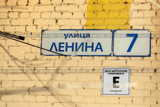 Город Королев, Московская область. Адресная табличка с названием улицы  "Улица Ленина, 7" на кирпичной стене дома. Табличка с надписью: "Класс энергетической эффективности "Е", пониженный" (2021 год). Стоковое фото, фотограф Наталья Николаева / Фотобанк Лори