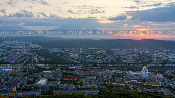Город Петропавловск-Камчатский, Камчатский край, Дальний Восток России. Утренний городской пейзаж. Вид сверху на собор, здания и улицы. Жилые городские районы на рассвете. Вдалеке вулканы. Стоковое фото, фотограф Андрей Степанов / Фотобанк Лори