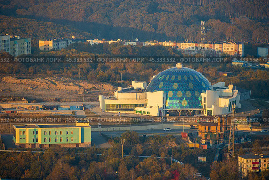 Город Петропавловск-Камчатский, Камчатский край, Россия. Вид сверху на здание кукольного театра. Большой разноцветный стеклянный купол современного театрального здания. Сооружение нового здания Камчатского театр кукол. Редакционное фото, фотограф Андрей Степанов / Фотобанк Лори
