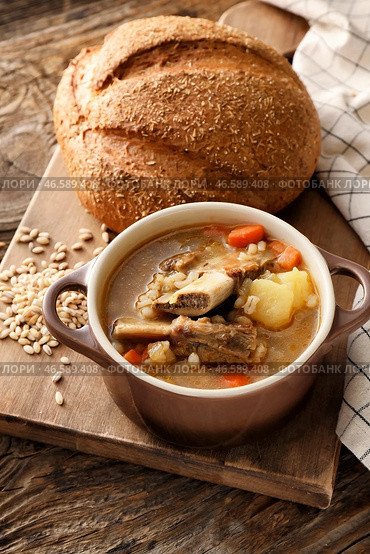 Горшок с вкусным говяжьим супом и буханкой хлеба на деревянном фоне. Стоковое фото, фотограф Pixel_shot / Фотобанк Лори