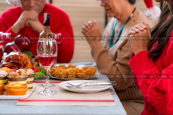 Grandfather leads a prayer and blessing before the family meal during the Christmas celebration at home. Стоковое фото, агентство Ingram Publishing / Фотобанк Лори