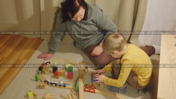 Grandmother playing toys with young grandson indoor. Old woman granny studying with her grandchild at weekend. Senior female having fun with kid. Happy multigeneration family video. Elderly Grandma. Стоковое видео, видеограф Марина Демидюк / Фотобанк Лори