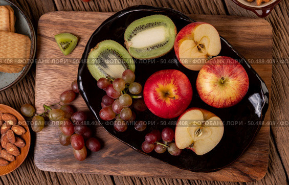 Grapes, kiwi, apples and bread on the table. Selective focus. Стоковое фото, агентство Ingram Publishing / Фотобанк Лори